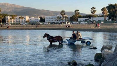 Hatay’da güneşli havanın keyfini çıkarmak isteyen 2 kişi, at arabasıyla