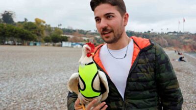 Antalya'da kürek sörfü yapan Tahir Özden, falezlerden düşen tavuğu kurtararak