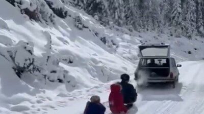 Çorum'un İskilip ilçesinde bir esnaf, aracının arkasına bağladığı kızaklarla çocuklarını