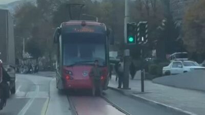 Bir çocuk, Bursa’nın Osmangazi ilçesinde seyir halindeki tramvayın arkasına oturarak