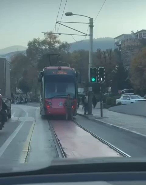 Bir çocuk, Bursa’nın Osmangazi ilçesinde seyir halindeki tramvayın arkasına oturarak
