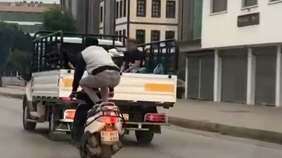 Adana’da bir şahsın, motosikleti önce çömelerek ardından yatarak kullanması çevredeki