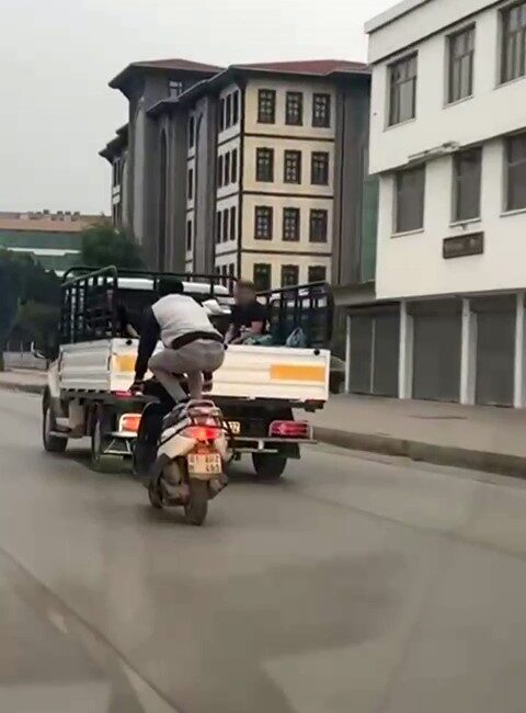Adana’da bir şahsın, motosikleti önce çömelerek ardından yatarak kullanması çevredeki