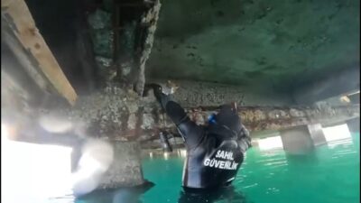 Balıkesir’in Edremit ilçesinde, deniz kıyısındaki iskele altında mahsur kalan bir