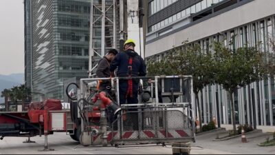 Bursa’da özel bir hastanenin dış cephe camlarını temizleyen 2 işçi,