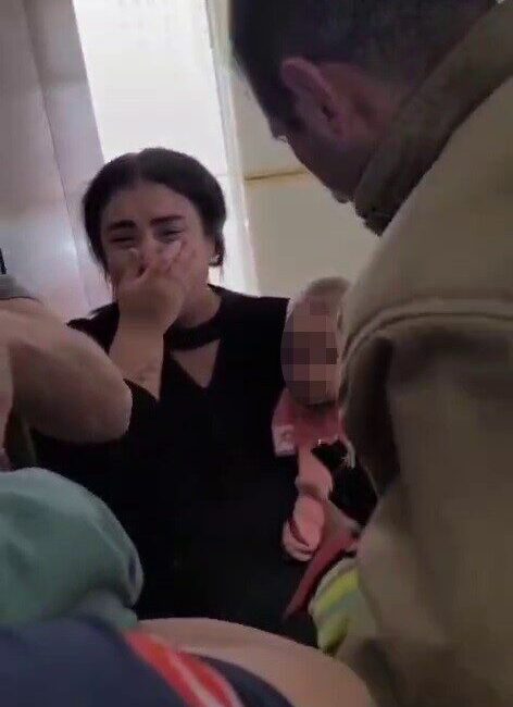 Hatay’da bir çocuk, evlerinin çelik kapısına elini sıkıştırarak acı içinde