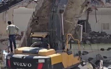 Kahta ilçesinde gerçekleşen kontrollü yıkım esnasında, iş makinesinin üzerine devrilen