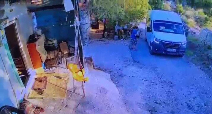 Serik ilçesinde bir baba, evinin önünde geri manevra yaptığı servis