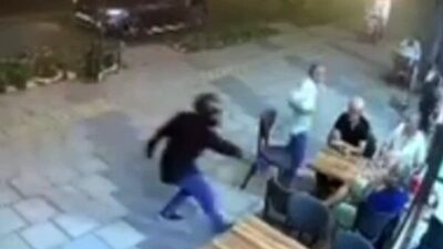Mersin’in Mezitli ilçesinde, kask takan bir kişi kaldırımdan yürürken bir