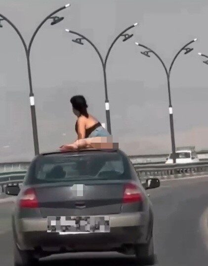 Manisa’nın Salihli ilçesinde, hareket halindeki bir otomobilin açılır tavanından çıkarak