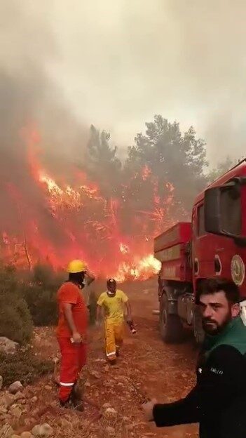 Aksu ilçesindeki yangınla mücadele eden ekipler, alevler arasında sıkışıp kalmaktan