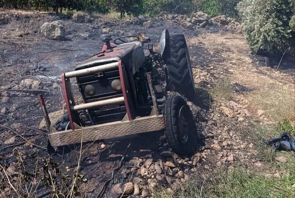 Hatay’ın Erzin ilçesinde otluk alanda başlayan yangında traktör alevlerin arasında