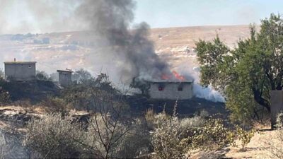 Nevşehir ilindeki otluk alanda başlayan yangın, rüzgarın etkisiyle bağ evlerinin