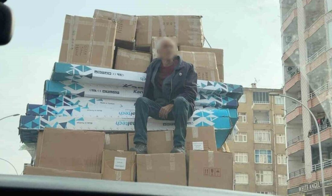 Diyarbakır’da, bir kişinin, kamyonetin kasasında kolilerin üstünde oturarak yolculuk etmesi