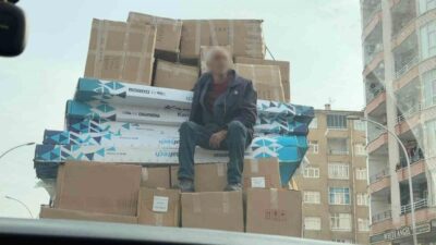 Diyarbakır’da, bir kişinin, kamyonetin kasasında kolilerin üstünde oturarak yolculuk etmesi